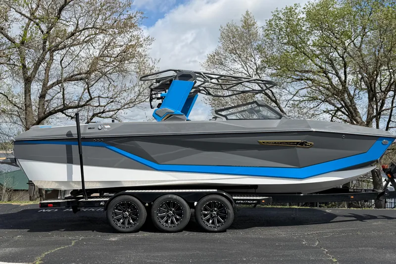 The Image of 2026 Nautique Super Air Nautique G25 boat on trailer, gray and blue design. - 6