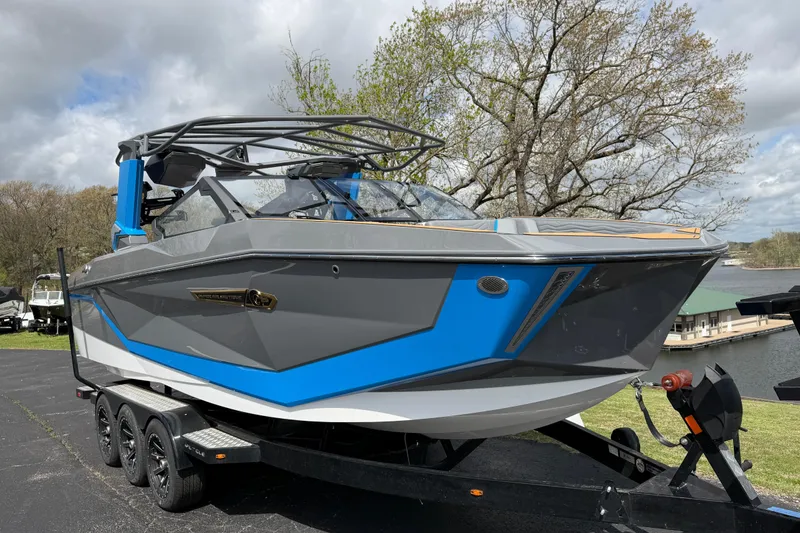 Slide: The Image of 2026 Nautique Super Air Nautique G25 boat on trailer, gray and blue design. - 13