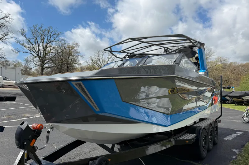 Slide: The Image of 2026 Nautique Super Air Nautique G25 boat on trailer under cloudy sky. - 12