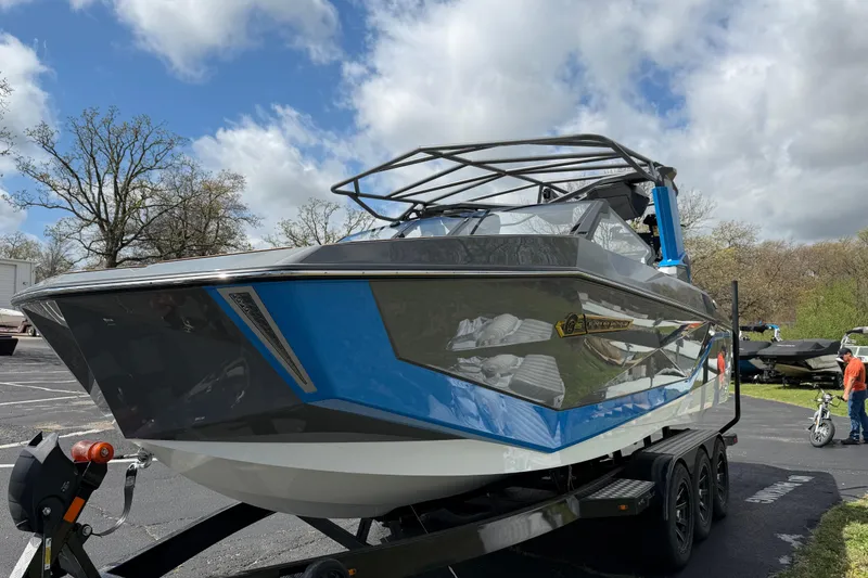 Slide: The Image of 2026 Nautique Super Air Nautique G25 boat on trailer under cloudy sky. - 11