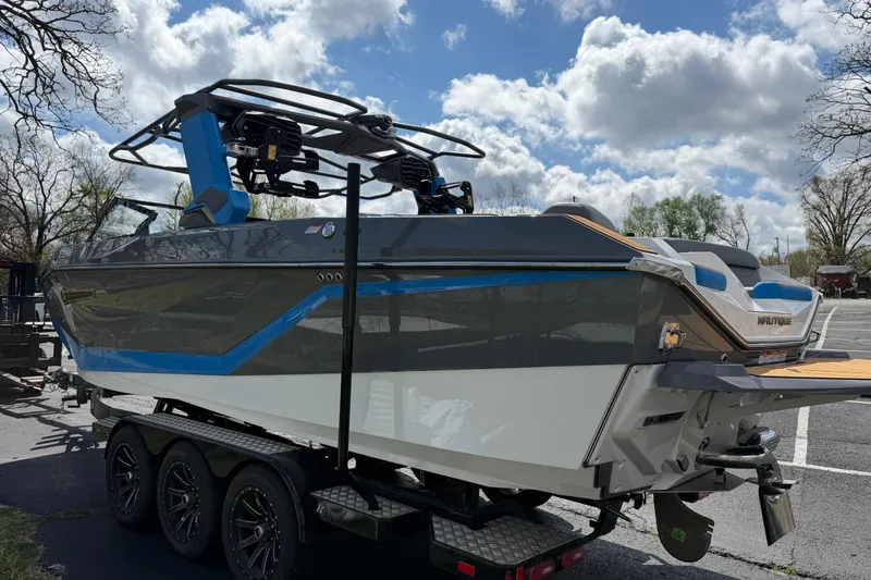 Slide: The Image of 2026 Nautique Super Air Nautique G25 boat on trailer under cloudy sky. - 10