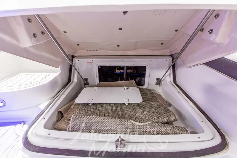Slide: The Image of 2017 Crownline Eclipse E1 XS boat storage compartment with carpeted interior. - 17