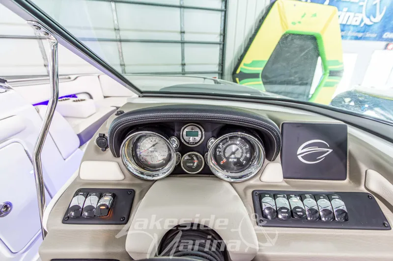 Slide: The Image of 2017 Crownline Eclipse E1 XS dashboard with gauges and controls in a marina setting. - 22