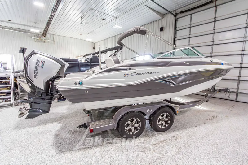 Slide: The Image of 2017 Crownline Eclipse E1 XS boat in a garage, featuring an Evinrude outboard motor. - 6