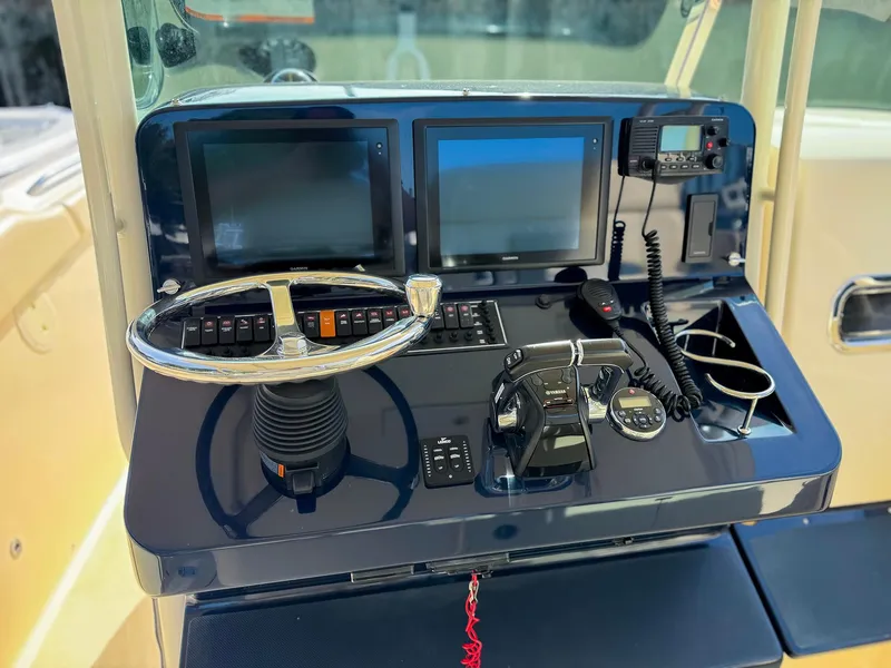 Slide: The Image of 2014 Pursuit ST 310 Sport boat dashboard with dual screens and controls. - 10