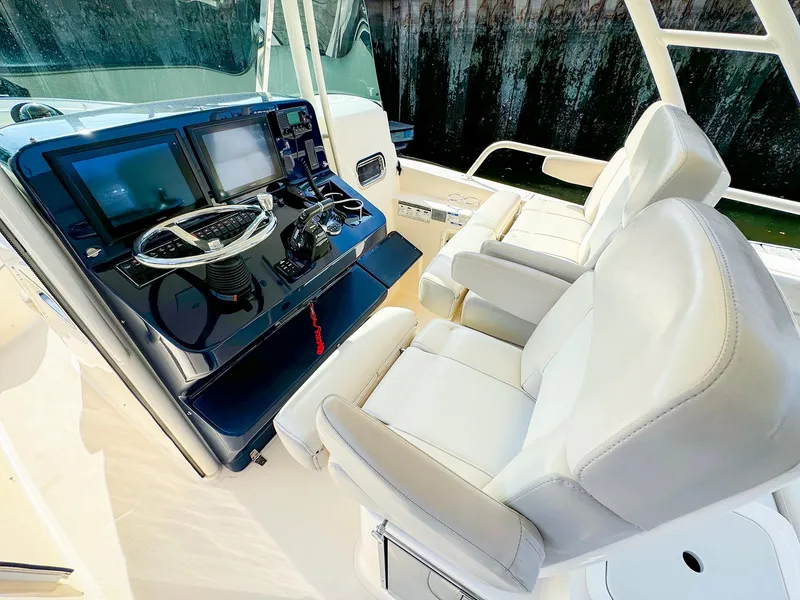 Slide: The Image of 2014 Pursuit ST 310 Sport boat cockpit with dual seats and navigation controls. - 13