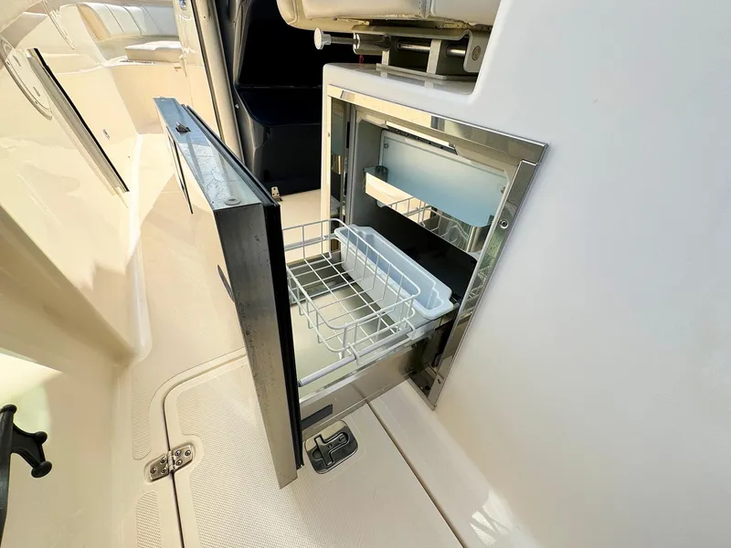 Slide: The Image of 2014 Pursuit ST 310 Sport boat with open built-in cooler drawer. - 18