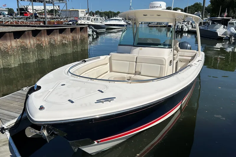 Slide: The Image of 2014 Pursuit ST 310 Sport boat docked in a marina, featuring sleek design and spacious seating. - 2