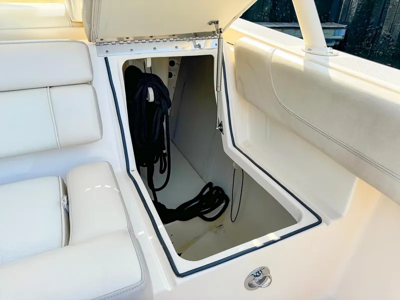 Slide: The Image of Open storage compartment on 2014 Pursuit ST 310 Sport boat with coiled rope inside. - 22