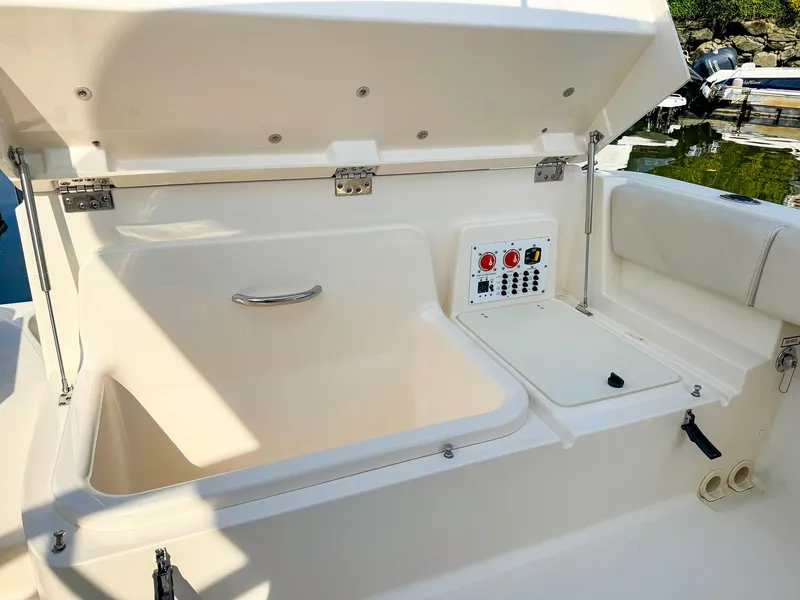 Slide: The Image of 2014 Pursuit ST 310 Sport boat storage compartment with control panel. - 26