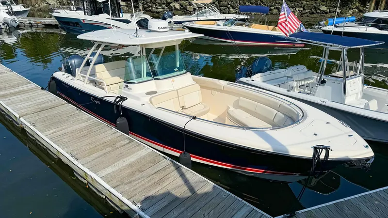 Slide: The Image of 2014 Pursuit ST 310 Sport boat docked in marina, featuring sleek design and spacious seating. - 3