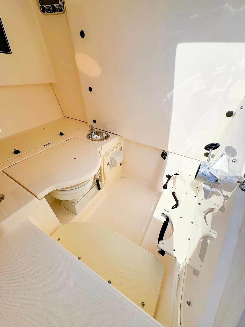 Slide: The Image of 2014 Pursuit ST 310 Sport boat interior with compact bathroom and sink. - 36