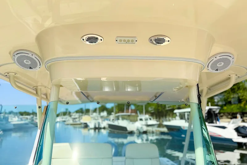 Slide: The Image of 2014 Pursuit ST 310 Sport boat interior with speakers, docked at marina. - 38