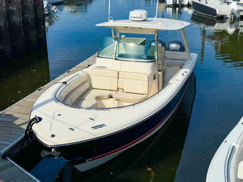 Slide: The Image of 2014 Pursuit ST 310 Sport boat docked in marina, featuring sleek design and Garmin equipment. - 4