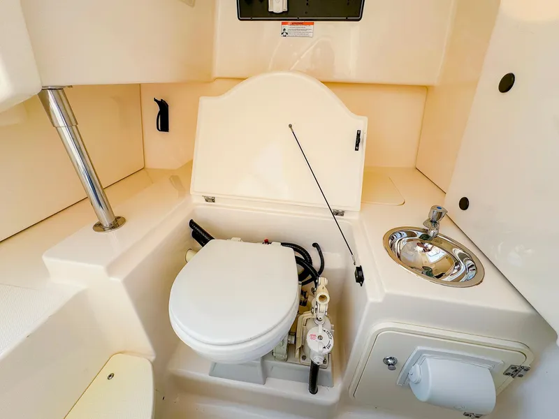 Slide: The Image of 2014 Pursuit ST 310 Sport boat interior with toilet and sink. - 40