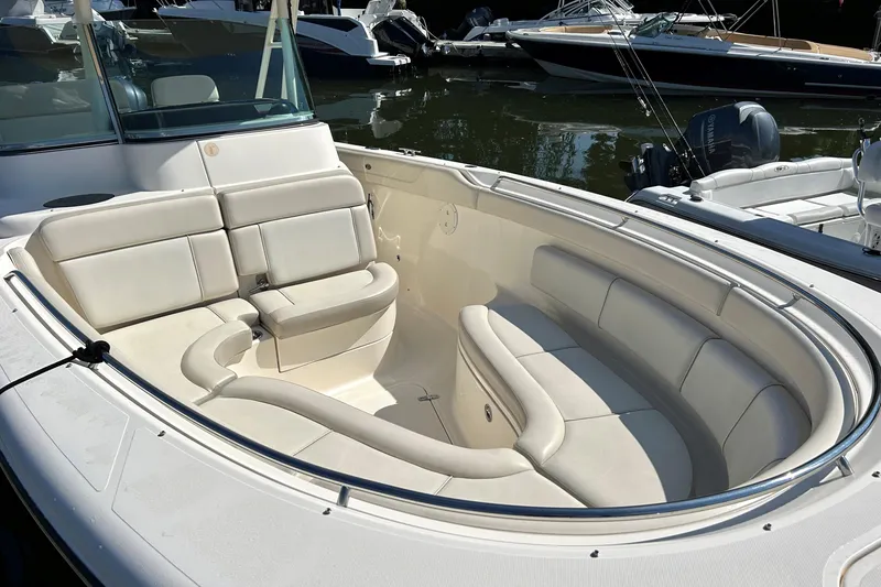 Slide: The Image of 2014 Pursuit ST 310 Sport boat with spacious seating, docked on calm water. - 6