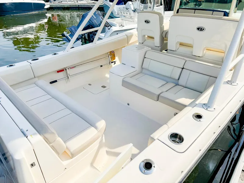 Slide: The Image of 2014 Pursuit ST 310 Sport boat interior with white seating and cup holders. - 7