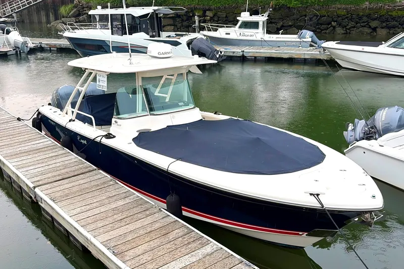 Slide: The Image of 2014 Pursuit ST 310 Sport boat docked, covered, with Yamaha engines, for sale sign visible. - 3