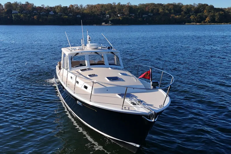 Slide: The Image of 2017 MJM 40z Downeast boat cruising on a serene lake. - 2