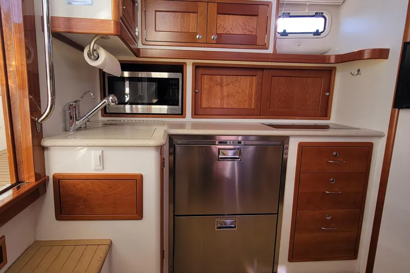 Slide: The Image of 2017 MJM 40z Downeast yacht kitchen with wood cabinets, stainless appliances, and modern fixtures. - 20