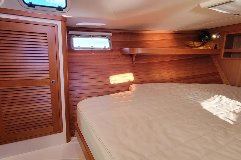 Slide: The Image of 2017 MJM 40z Downeast cabin interior with wooden paneling and cozy bed. - 23