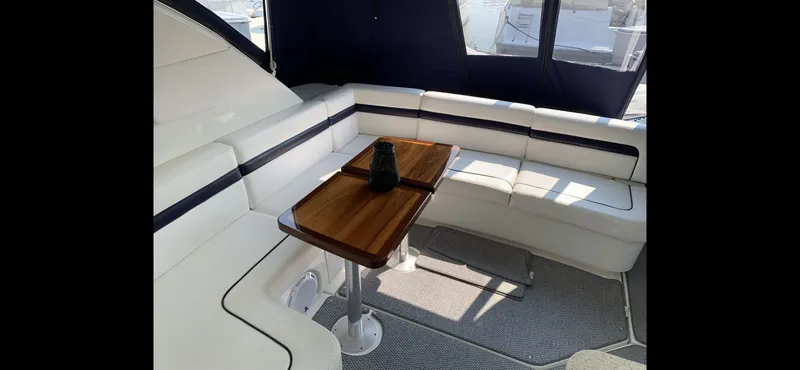 Slide: The Image of Interior of 2010 Sea Ray 470 Sundancer with white sofa and wooden table. - 16