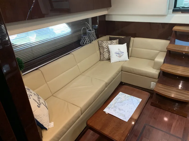 Slide: The Image of Interior of 2010 Sea Ray 470 Sundancer with beige sofa and wooden table. - 19