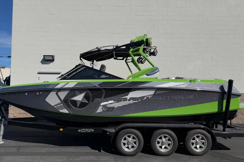 The Image of 2014 Nautique Super Air Nautique G23 boat with green and gray design on a trailer. - 0