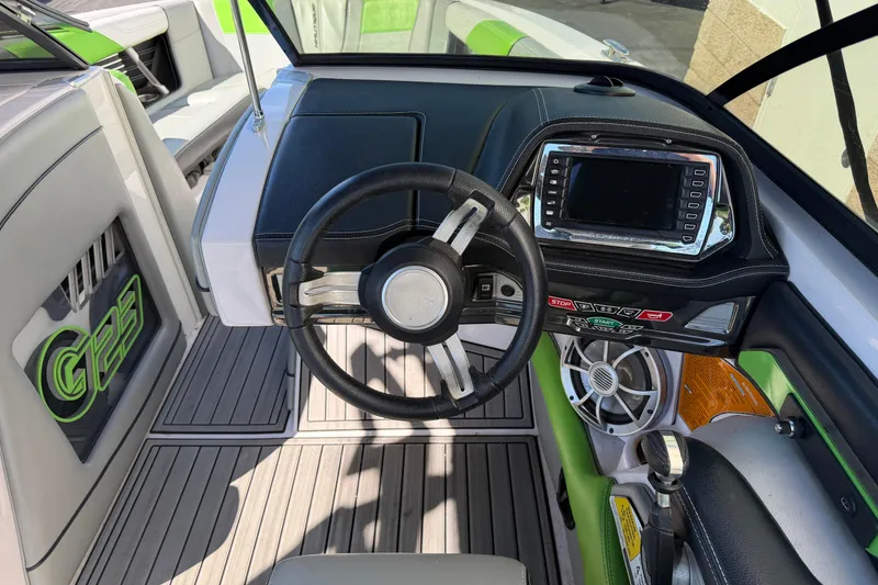 Slide: The Image of 2014 Nautique Super Air Nautique G23 dashboard with steering wheel and control panel. - 11