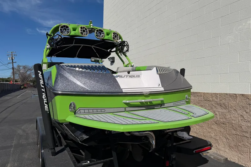 Slide: The Image of 2014 Nautique Super Air Nautique G23 boat in vibrant green, parked outdoors. - 2