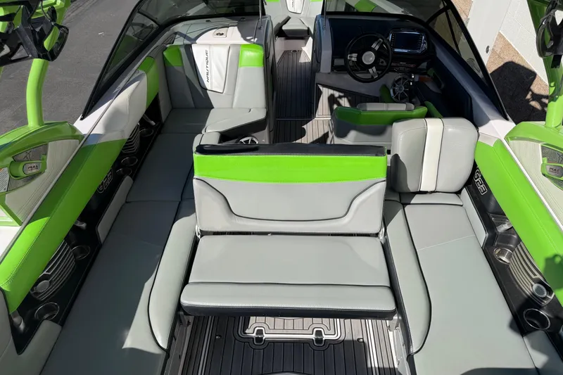 Slide: The Image of 2014 Nautique Super Air Nautique G23 interior with green and gray seating, modern dashboard. - 5