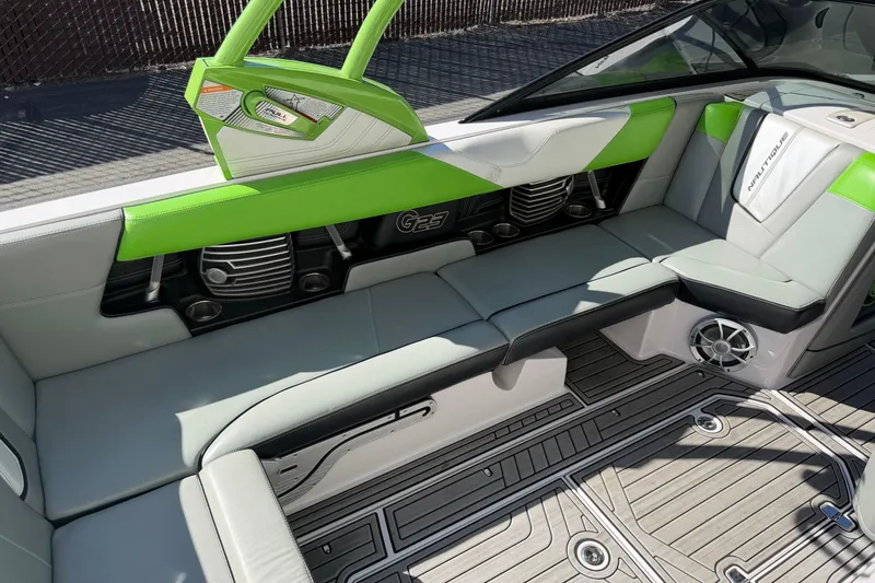 Slide: The Image of 2014 Nautique Super Air Nautique G23 interior with green accents and modern seating design. - 8