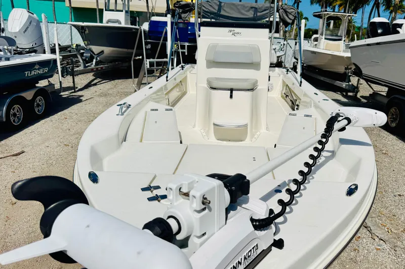 Slide: The Image of 2023 KenCraft 219 Bay Rider boat with Minn Kota trolling motor, parked outdoors. - 17