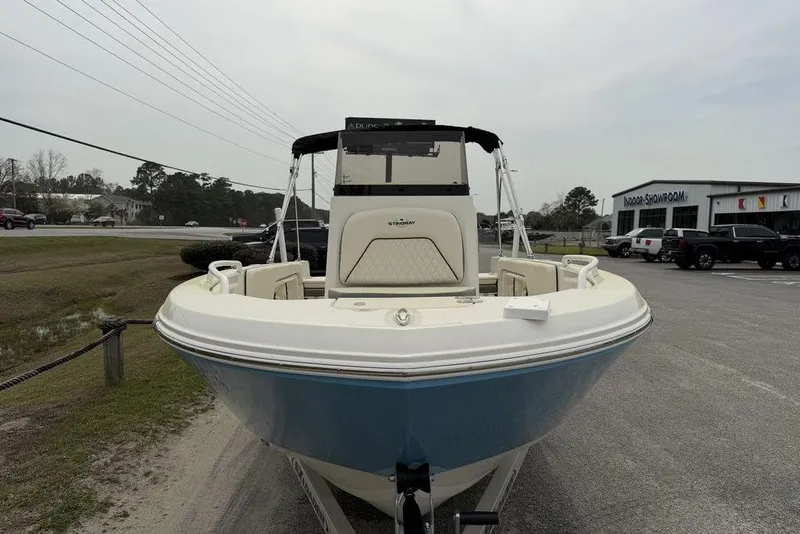 Slide: The Image of 2023 Stingray 173 CC boat displayed outdoors near showroom. - 7