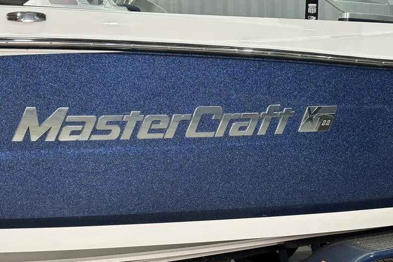 Slide: The Image of 2019 MasterCraft XT22 boat with metallic blue finish and logo detail. - 3