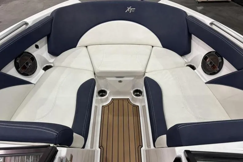Slide: The Image of 2019 MasterCraft XT22 boat interior with blue and white seating and teak flooring. - 8