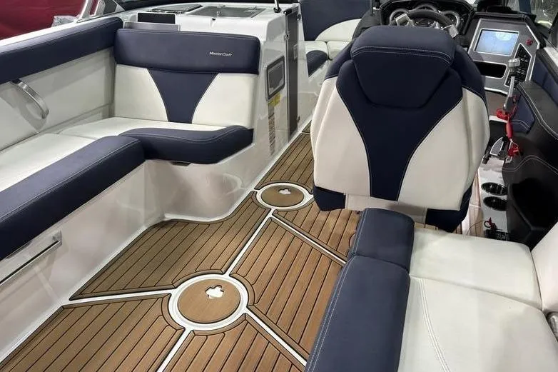 Slide: The Image of 2019 MasterCraft XT22 boat interior with luxurious seating and wood-style flooring. - 9