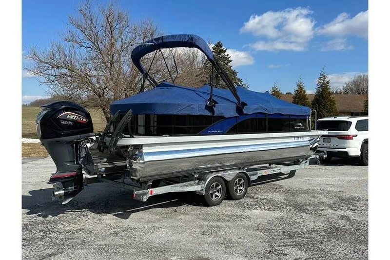 Slide: The Image of 2022 Bennington 24 SXSR Tritoon with Yamaha Vmax 250 SHO on trailer, parked outdoors. - 4