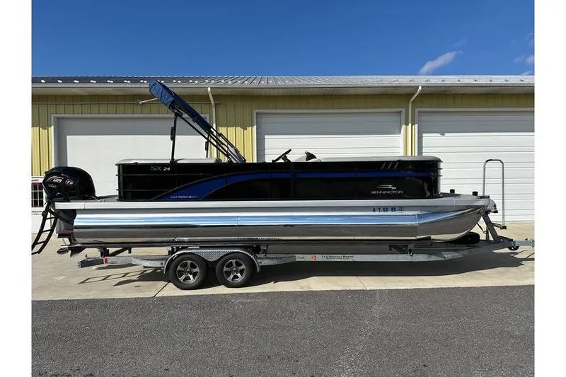Slide: The Image of 2022 Bennington 24 SXSR Tritoon with Yamaha Vmax 250 SHO on trailer, parked outdoors. - 7