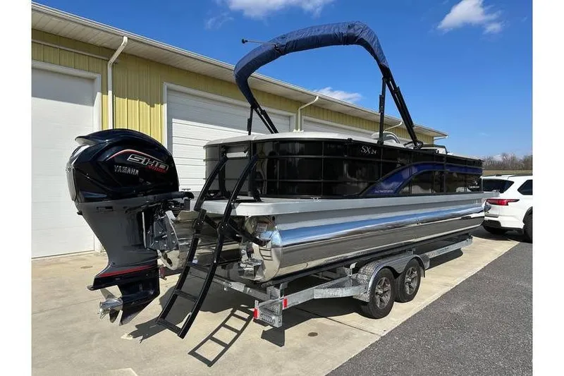 Slide: The Image of 2022 Bennington 24 SXSR Tritoon with Yamaha Vmax 250 SHO on trailer, parked outdoors. - 8