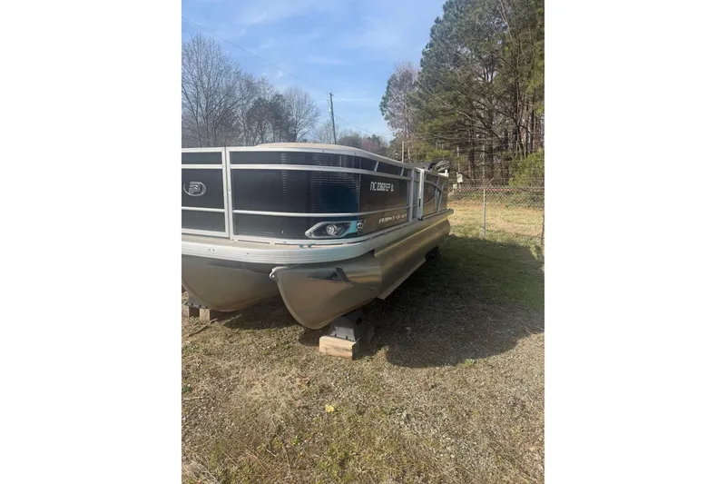 The Image of 2020 Princecraft Vectra 23 pontoon boat on grass, surrounded by trees. - 0