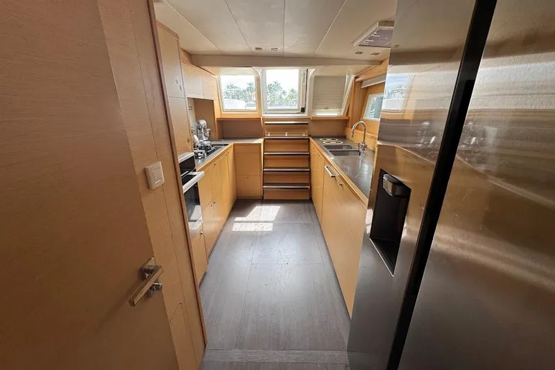 Slide: The Image of Modern yacht kitchen interior with wooden cabinetry, stainless steel appliances, and ample natural light, Lagoon 2015. - 19