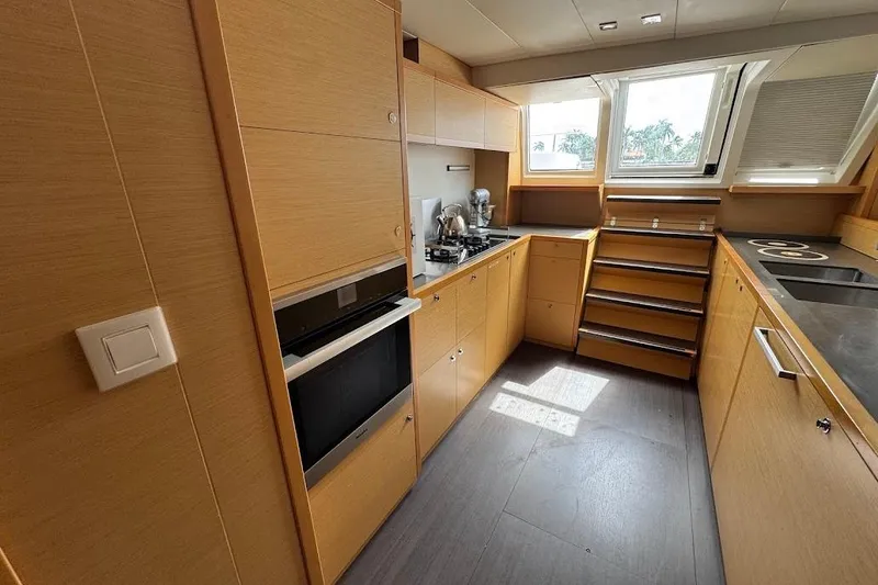 Slide: The Image of Modern yacht kitchen interior with wooden cabinetry, appliances, and large windows, Lagoon 2015 model. - 21