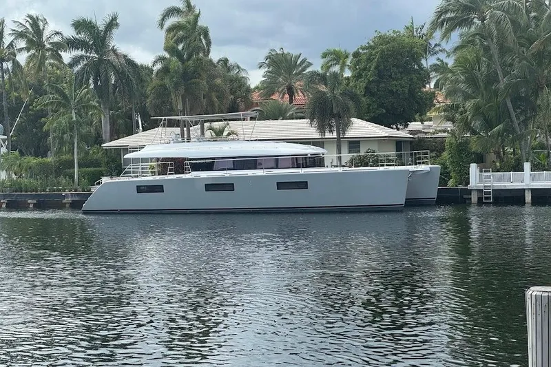 Slide: The Image of Luxury Lagoon yacht docked by waterfront home, surrounded by palm trees, 2015 model. - 29