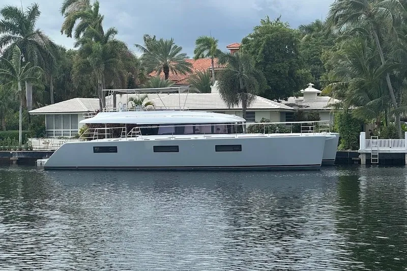 Slide: The Image of Luxury Lagoon yacht docked by waterfront home, surrounded by palm trees, 2015 model. - 5