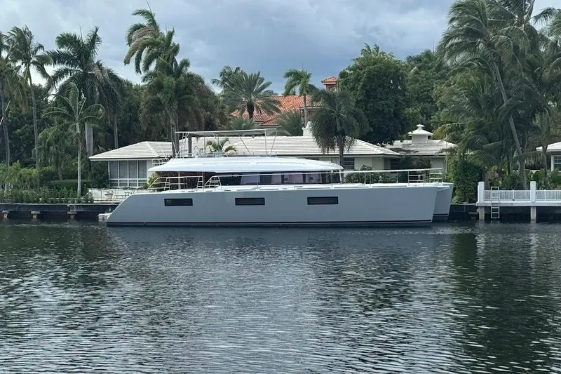 Slide: The Image of Luxurious 2015 Lagoon yacht docked by waterfront home with palm trees. - 6