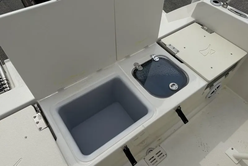 Slide: The Image of 2004 Robalo R260 Center Console boat interior with toilet and storage area. - 14