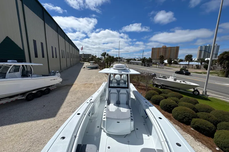 Slide: The Image of 2026 Yellowfin 36 Offshore boat displayed outdoors, with clear skies and nearby buildings. - 10