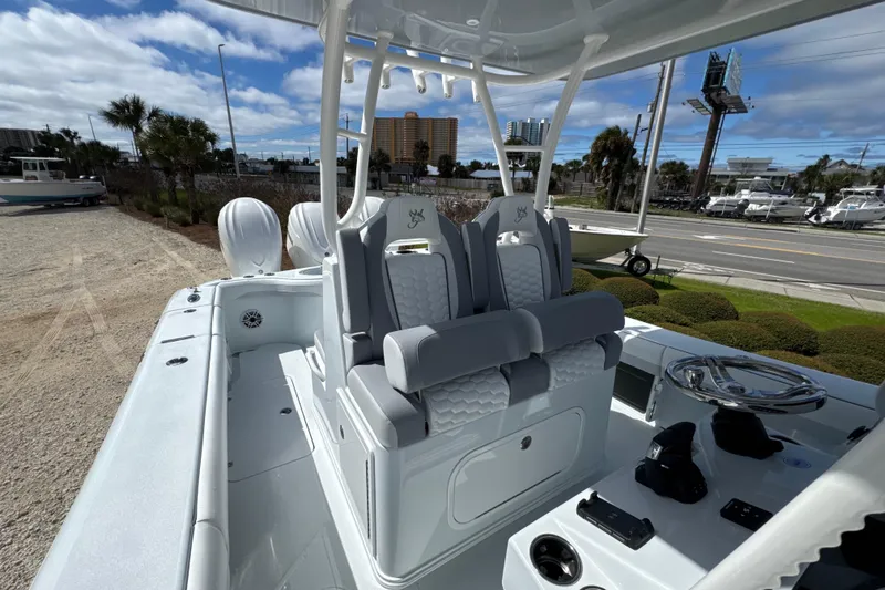 Slide: The Image of 2026 Yellowfin 36 Offshore boat with sleek seating and modern controls, docked outdoors. - 16
