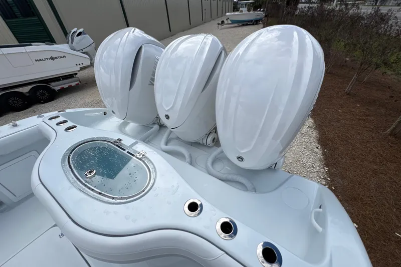 Slide: The Image of 2026 Yellowfin 36 Offshore boat with triple outboard engines and livewell, parked outdoors. - 26